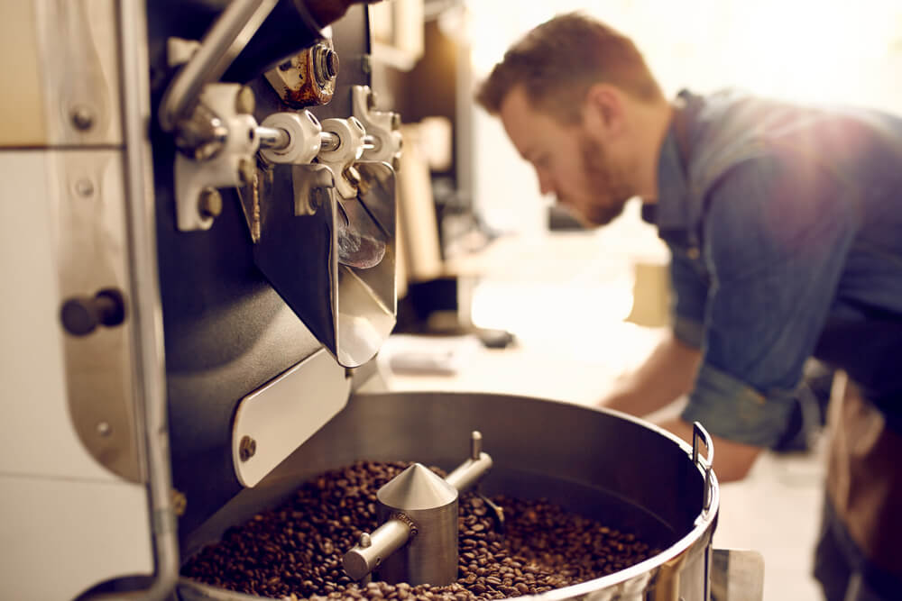 Roastery machine with fresh roasted coffee beans | Oro Caffè